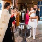Ο ιερέας, ο νονός με την ποδιά «Ο νονός μου» και οι γονείς με τη μικρή, δίπλα στην κολυμβήθρα