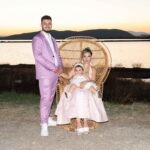 Ο μπαμπάς κρατάει το χέρι της μαμάς, που κάθεται με τη μικρή στην ψάθινη πολυθρόνα