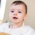 Η Φωτεινή χαμογελά με ανοιχτό στόμα μετά τη βάπτισή της στο Νεοχώρι