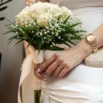 Το μπουκέτο της νύφης με λευκά τριαντάφυλλα, γυψοφίλη και κορδέλα σε χρώμα ιβουάρ