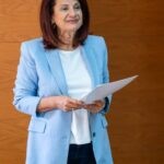 Η κυρία Παπαγεωργίου με γαλάζιο σακάκι κρατά τα χαρτιά του πολιτικού γάμου