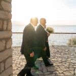 Ο γαμπρός με την ανθοδέσμη στο προαύλιο του ναού, με τη λίμνη στο βάθος