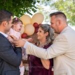 Η Ερατώ και ο Παναγιώτης δίπλα στον νονό που κρατά τη Μαριάνθη με το ροζ φορεματάκι