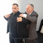 Συγγενής βοηθά τον γαμπρό να φορέσει το σακάκι του
