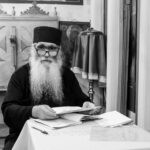 Ο ιερέας της βάπτισης διαβάζει στο αναλόγιο, σε ασπρόμαυρη φωτογραφία