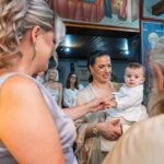 Η νονά κρατά το χεράκι του Γεράσιμου στην αρχή του μυστηρίου