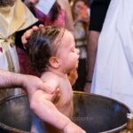 Ο ιερέας βαπτίζει την Αλίνα μέσα στην κολυμβήθρα
