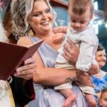 Η νονά κρατά τον Γεράσιμο πάνω από την κολυμβήθρα