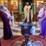 Η Μαριάνθη με το λευκό φόρεμα στην αγκαλιά της Ερατώς, με τον Παναγιώτη και τους νονούς μπροστά στο τέμπλο