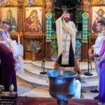 Ο ιερέας ευλογεί την οικογένεια και τους νονούς μπροστά στο τέμπλο της Αγίας Παρασκευής
