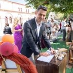 Ο νονός γράφει την ευχή του στο βιβλίο ευχών δίπλα στον στολισμό