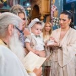 Η Νεκταρία κρατά τα παπουτσάκια του Γεράσιμου μπροστά στον ιερέα