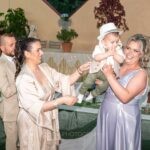 Η νονά σηκώνει ψηλά τον Γεράσιμο δίπλα στο τραπέζι της δεξίωσης στο Ίναχος