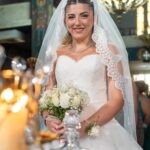 Η νύφη με την ανθοδέσμη μέσα στον Άγιο Νικόλαο, κάτω από τον πολυέλαιο
