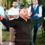 Ο γαμπρός χορεύει με ανοιχτά χέρια, με τους φίλους του γύρω