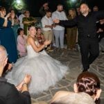 Ο γαμπρός χορεύει στη μέση του κύκλου και η νύφη τον χειροκροτεί